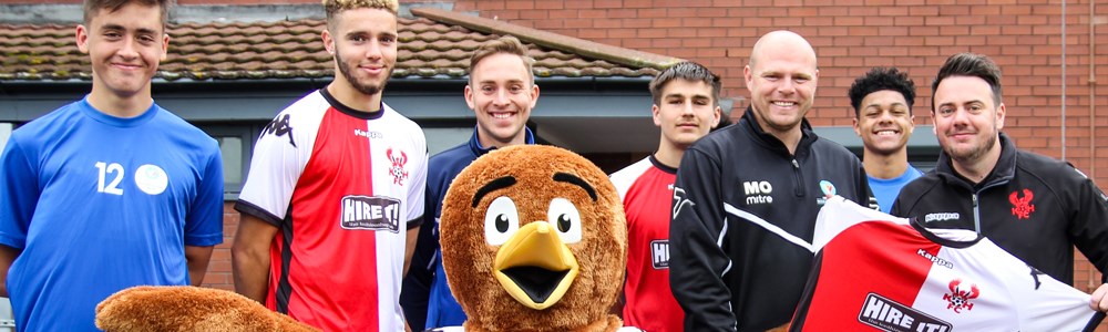 Group of male football students and bird mascot holding a football tshirt with a large logo on