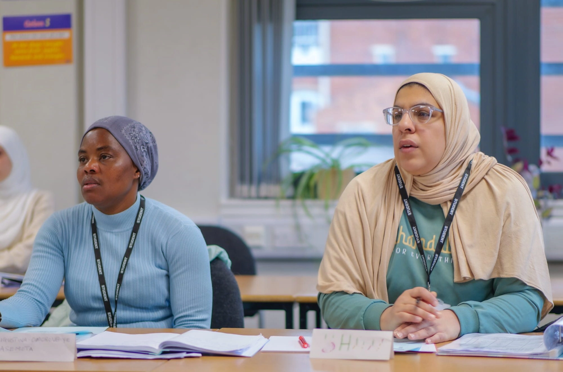2 students in a classroom during an ESOL lesson looking at the front of the room