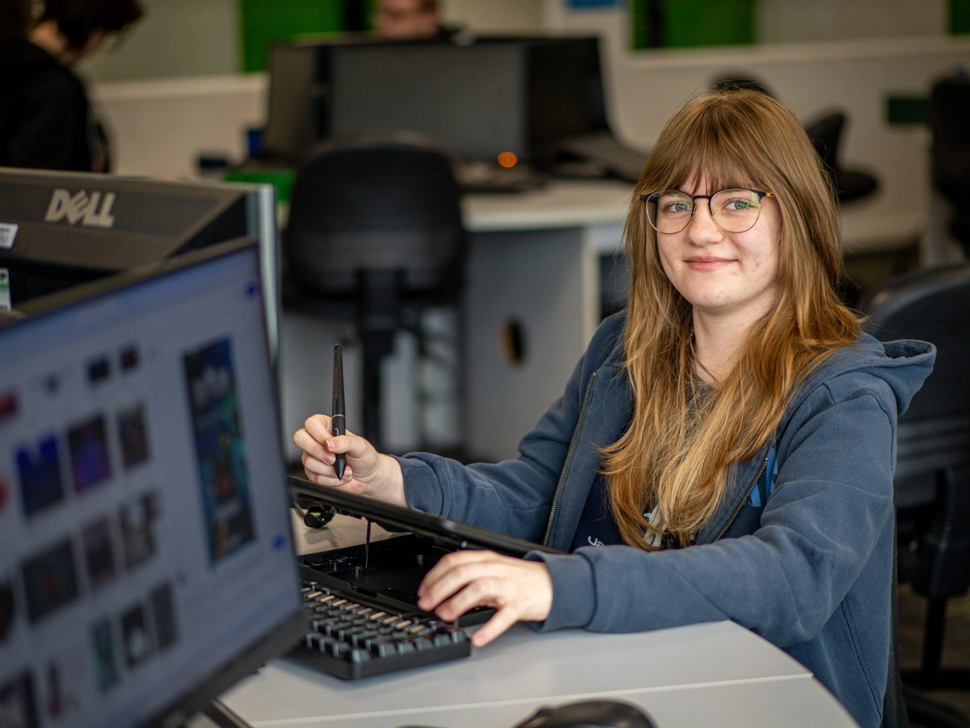 Student smiling in computer classroom jpg