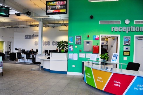 Interior image of Heart of Worcestershire College's Redditch Peakman campus showing the reception desk and student advice area