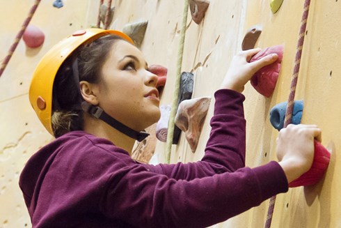 A female student climbing an indoor climbing wall