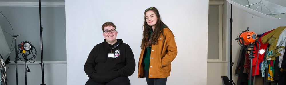 Male and female student smiling in a photography studio