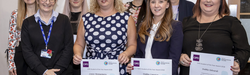 Group of female students and teachers holding certificates at awards evening