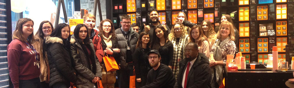 Large group photo of students smiling in T2Tea shop