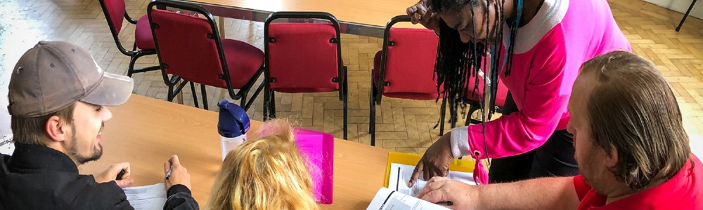 Group of adults sat around a desk looking at paper work