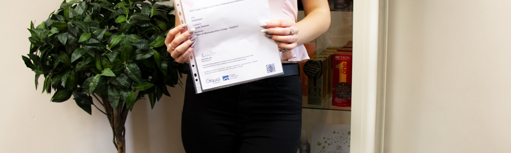 Female student smiling and holding a certificate