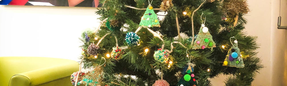 College christmas tree with graduation photo hung on the wall in the background.