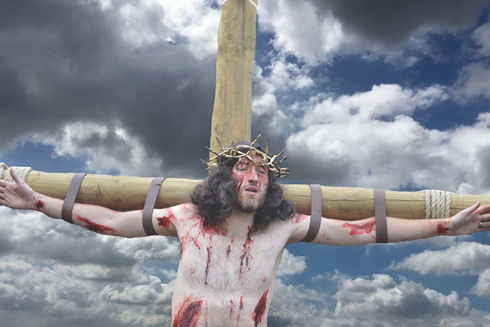 Actor portraying Jesus is strapped to a wooden cross in relation to an upcoming performance of Wintershall Passion Play