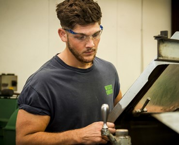 A male engineering student working on a machine