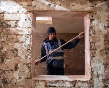 Image of a student holding building materials inside a structure