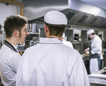 Two chefs talking in a kitchen 