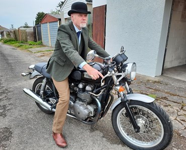 Man dressed dapper on a motorcycle